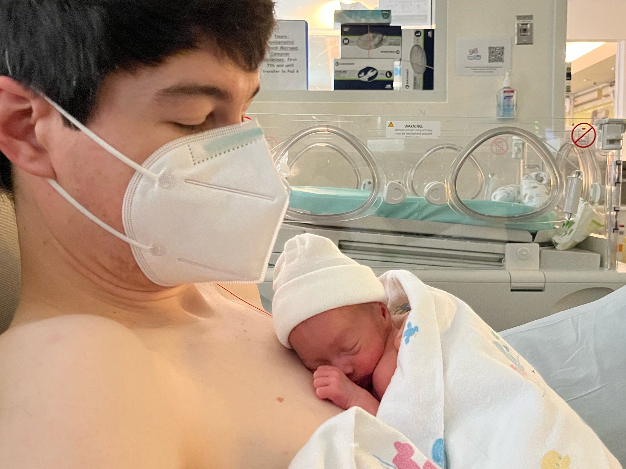 Father holding a premature newborn baby